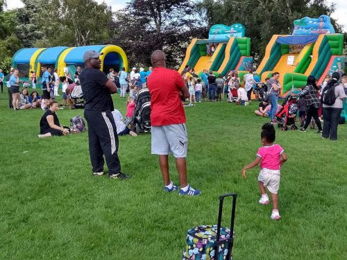 An outdoor event with inflatable slides and bounce houses