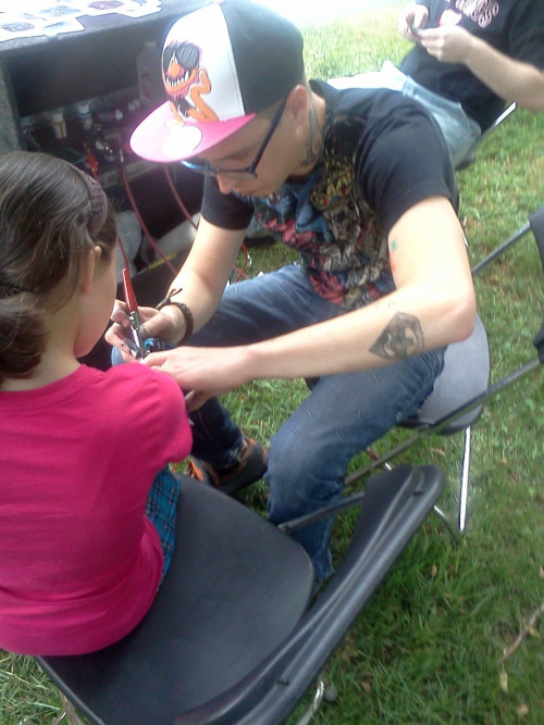 Artist applying a temporary tattoo with an airbrush